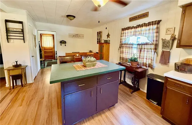 a view of a kitchen with kitchen island granite countertop a sink and wooden floor
