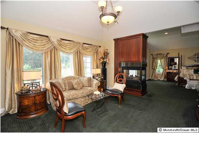 114 Stone Hill Road Colts Neck, NJ 07722 - Photo 15 of 25 a living room with furniture a fireplace and a large window