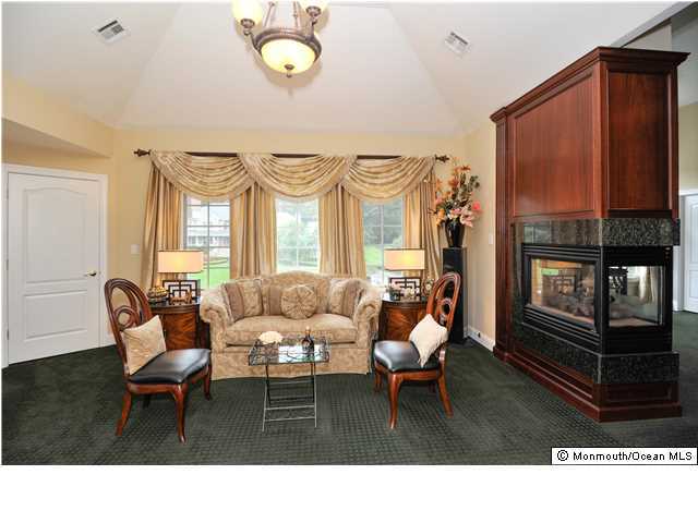 114 Stone Hill Road Colts Neck, NJ 07722 - Photo 16 of 25 a living room with furniture a fireplace and large windows