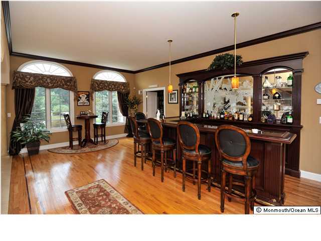 114 Stone Hill Road Colts Neck, NJ 07722 - Photo 3 of 25 a dining hall view with a large dining table and chairs with wooden floor
