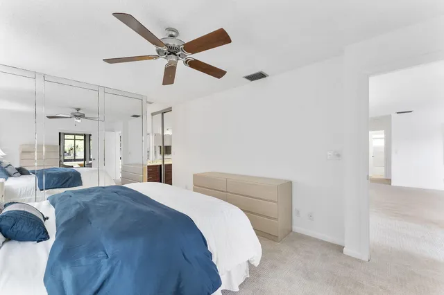 a spacious bedroom with a bed and ceiling fan