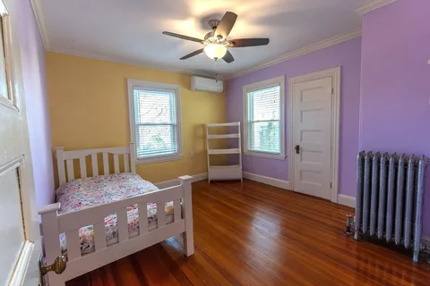 a bedroom with furniture and wooden floor