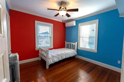 a bedroom with a bed and wooden floor