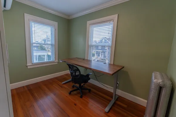 a view of a workspace with furniture and a window