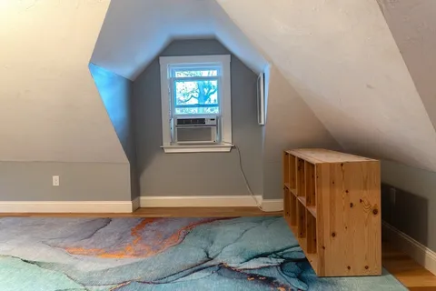 a view of a livingroom with wooden floor and a window