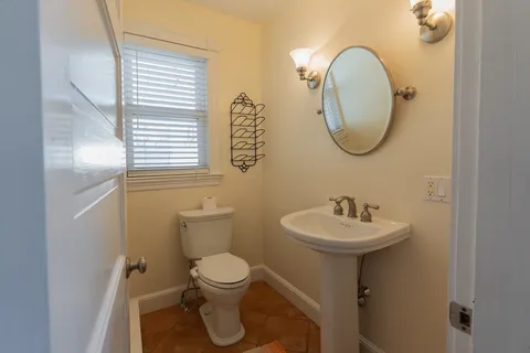 a bathroom with a toilet sink and mirror