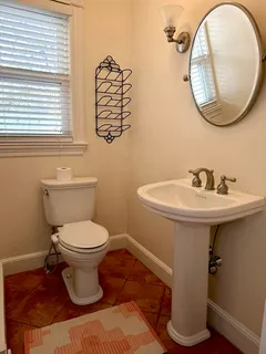 a bathroom with a toilet a sink and a mirror