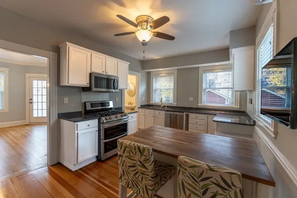 a kitchen with stainless steel appliances granite countertop a stove refrigerator and microwave