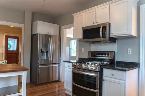 a kitchen with stainless steel appliances granite countertop a stove microwave and refrigerator