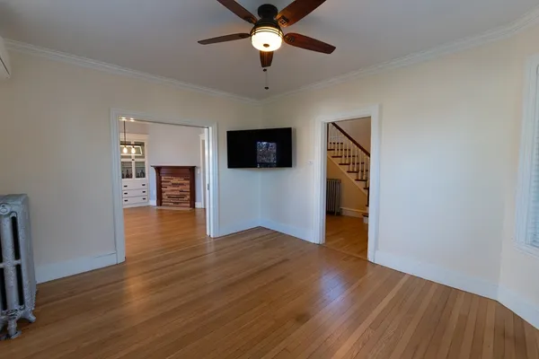 a view of a livingroom with a hardwood floor and a ceiling fan