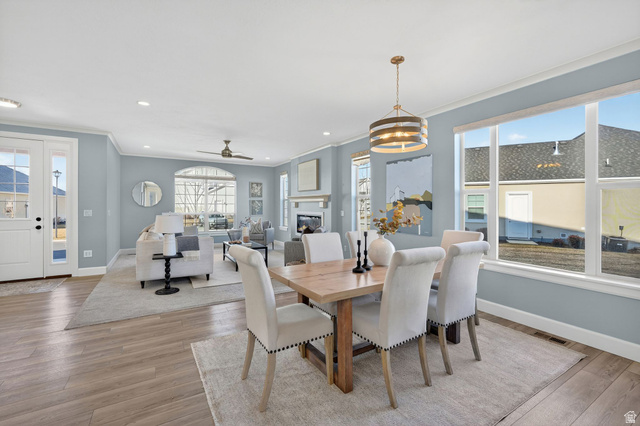 1222 West 190th Street North Mapleton, UT 84664 - Photo 9 of 46 Open concept living and dining areas featuring wood-finish flooring, a contemporary dining chandelier, and large windows