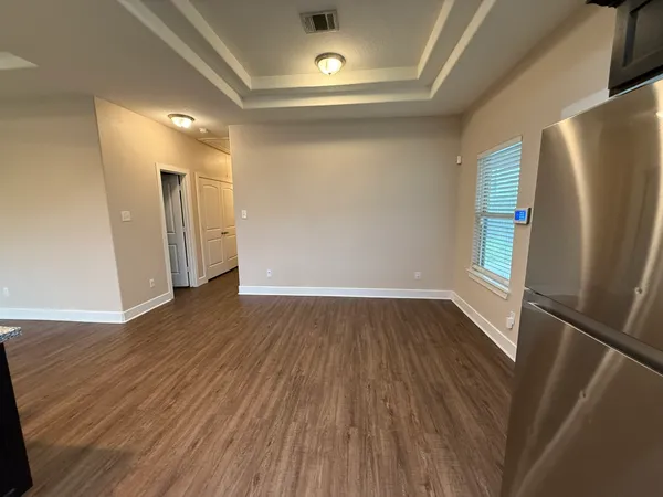 a view of empty room with wooden floor