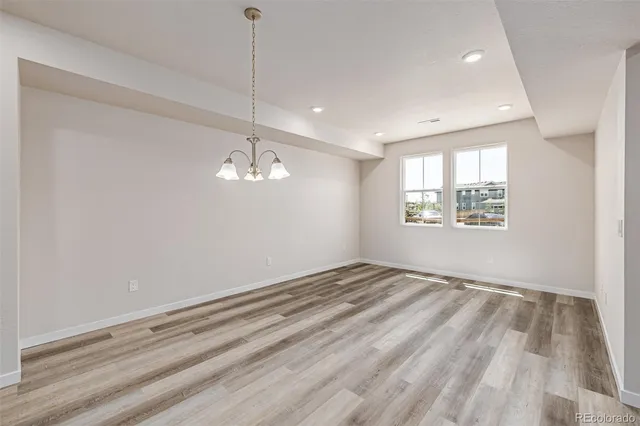 a view of empty room with wooden floor and ceiling fan