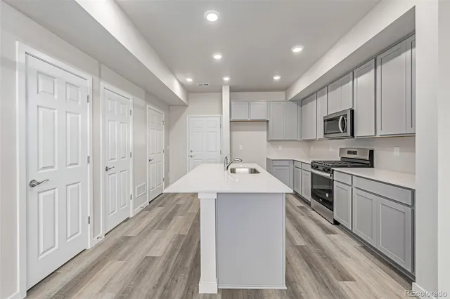 a kitchen with granite countertop a sink stainless steel appliances and cabinets
