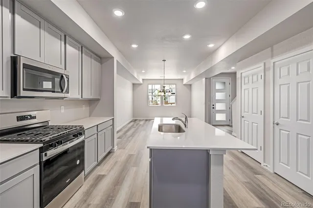a kitchen with stainless steel appliances granite countertop a sink stove and microwave