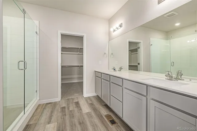 a spacious bathroom with a double vanity sink and mirror