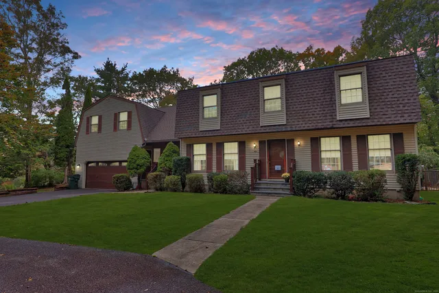 a front view of a house with a yard and trees