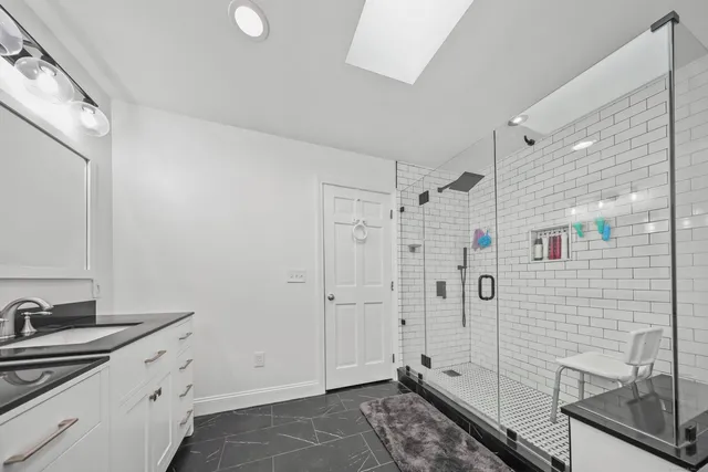 a bathroom with a double vanity sink a mirror and shower