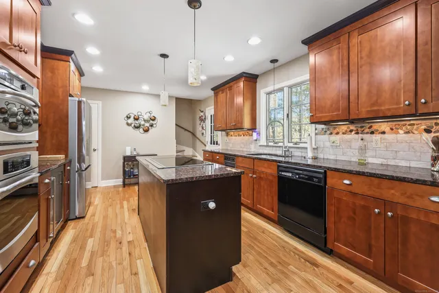 a kitchen with granite countertop a sink stove and refrigerator