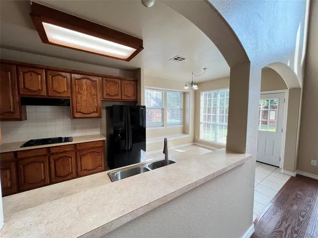 a kitchen with stainless steel appliances granite countertop a refrigerator oven stove sink and cabinets