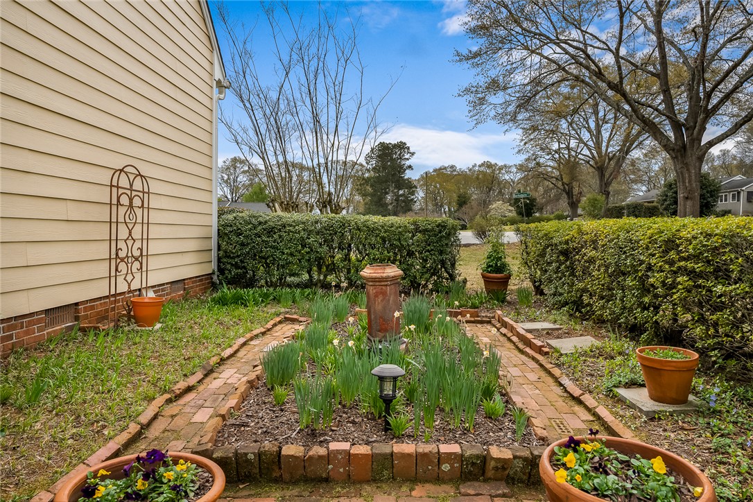 401 Berkshire Hill Anderson, SC 29621 - Photo 35 of 39 A quaint brick pathway leads through a manicured garden with lush foliage.