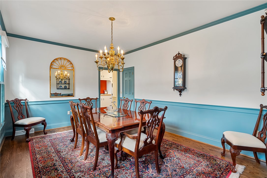 401 Berkshire Hill Anderson, SC 29621 - Photo 7 of 39 Elegant dining space featuring rich hardwood floors, an ornate chandelier, and classic architectural trim.