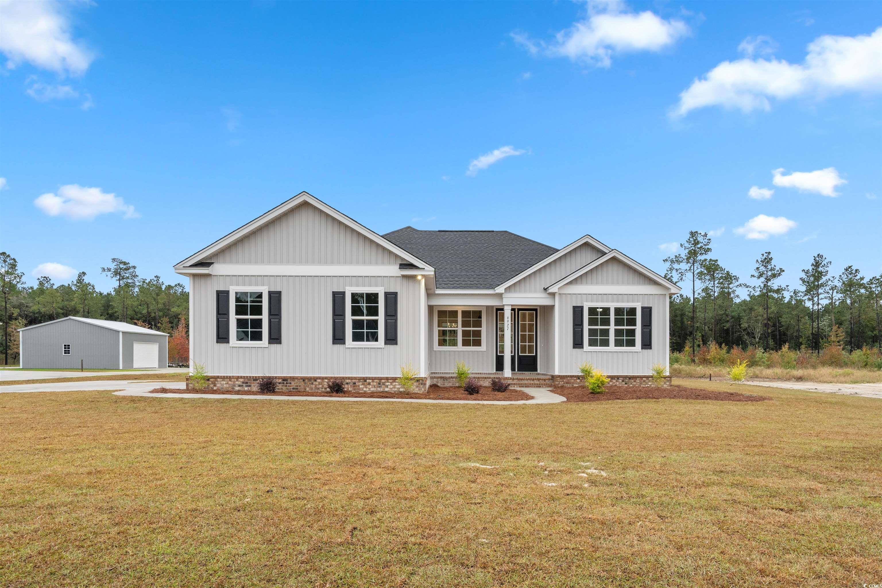 View of front of house with a front lawn, roof with shingles, and covered porch