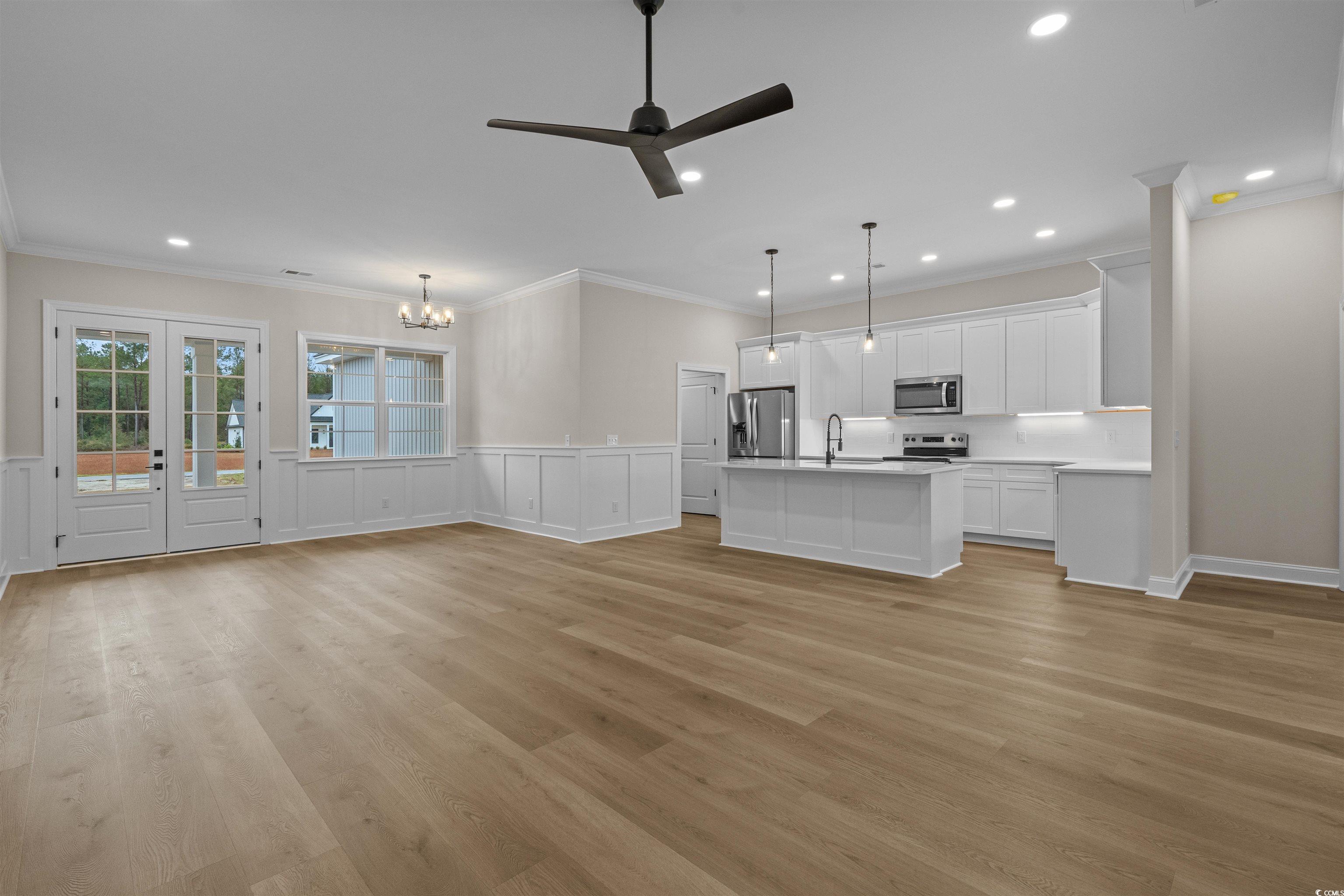 6927 Pauley Swamp Road Conway, SC 29527 - Photo 10 of 40 Unfurnished living room featuring ornamental molding, light wood-style floors, ceiling fan, a chandelier, and recessed lighting