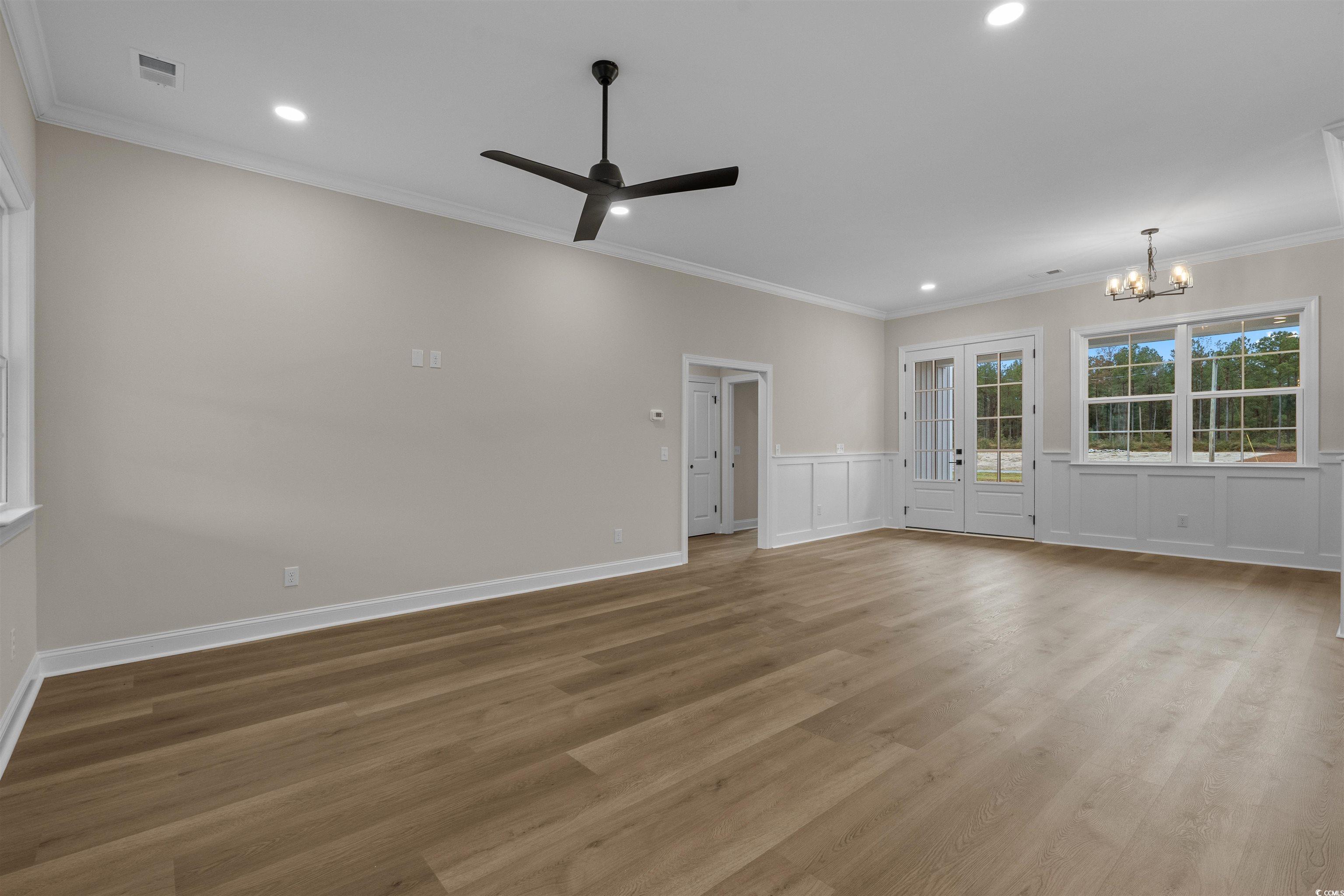 6927 Pauley Swamp Road Conway, SC 29527 - Photo 11 of 40 Spare room featuring crown molding, light wood-style floors, recessed lighting, ceiling fan, and a chandelier
