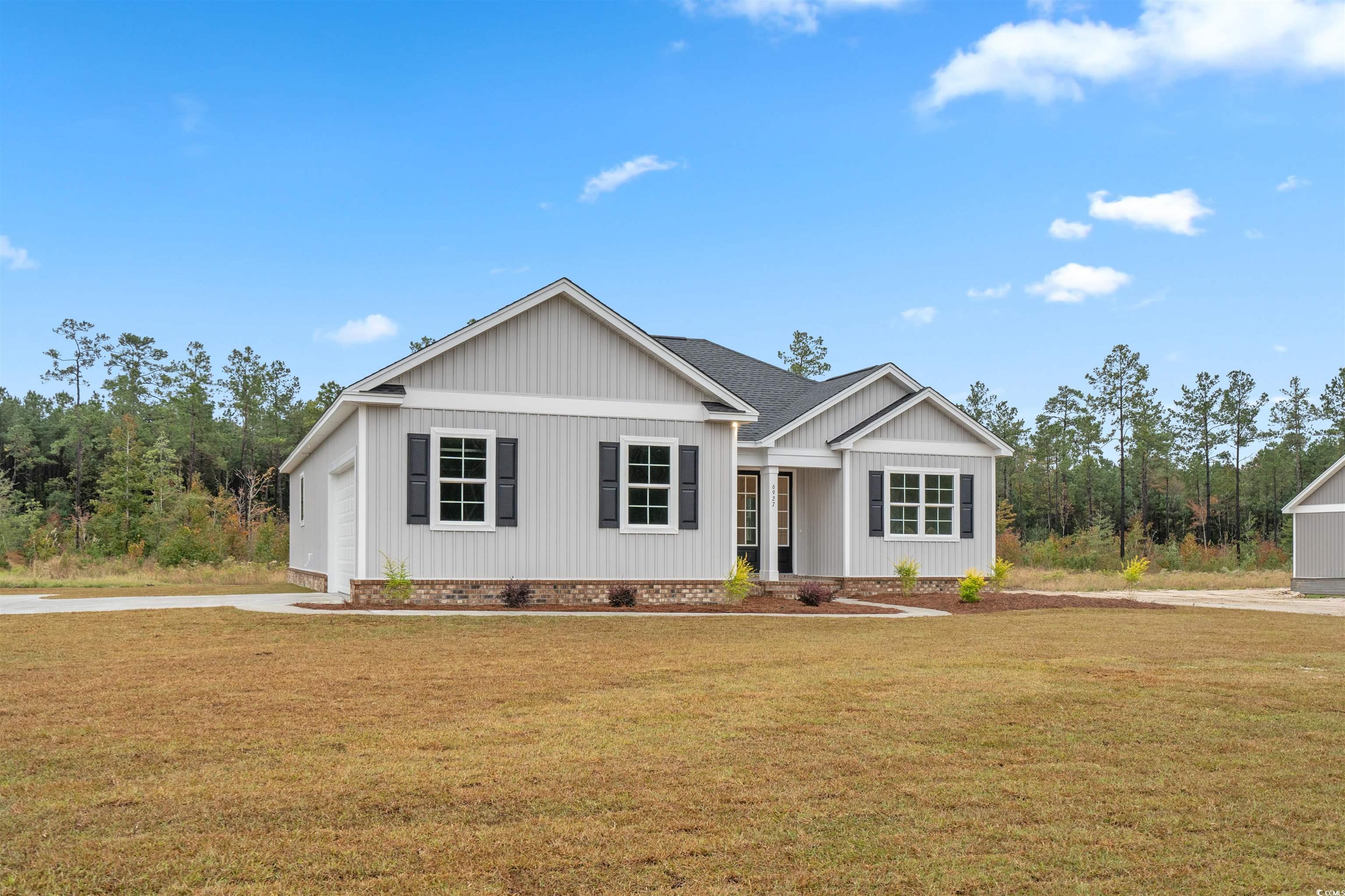 6927 Pauley Swamp Road Conway, SC 29527 - Photo 2 of 40 View of front facade featuring a front yard, a shingled roof, concrete driveway, and crawl space