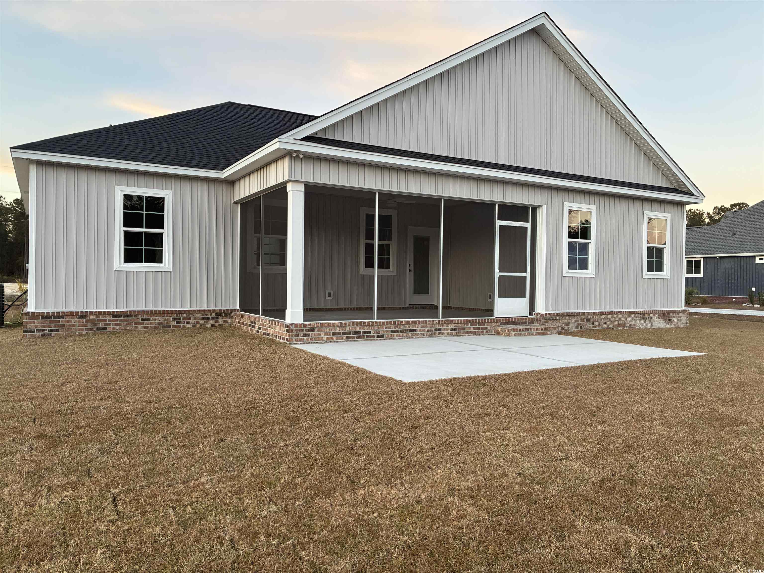 6927 Pauley Swamp Road Conway, SC 29527 - Photo 22 of 40 Back of property with a sunroom, a shingled roof, and a lawn