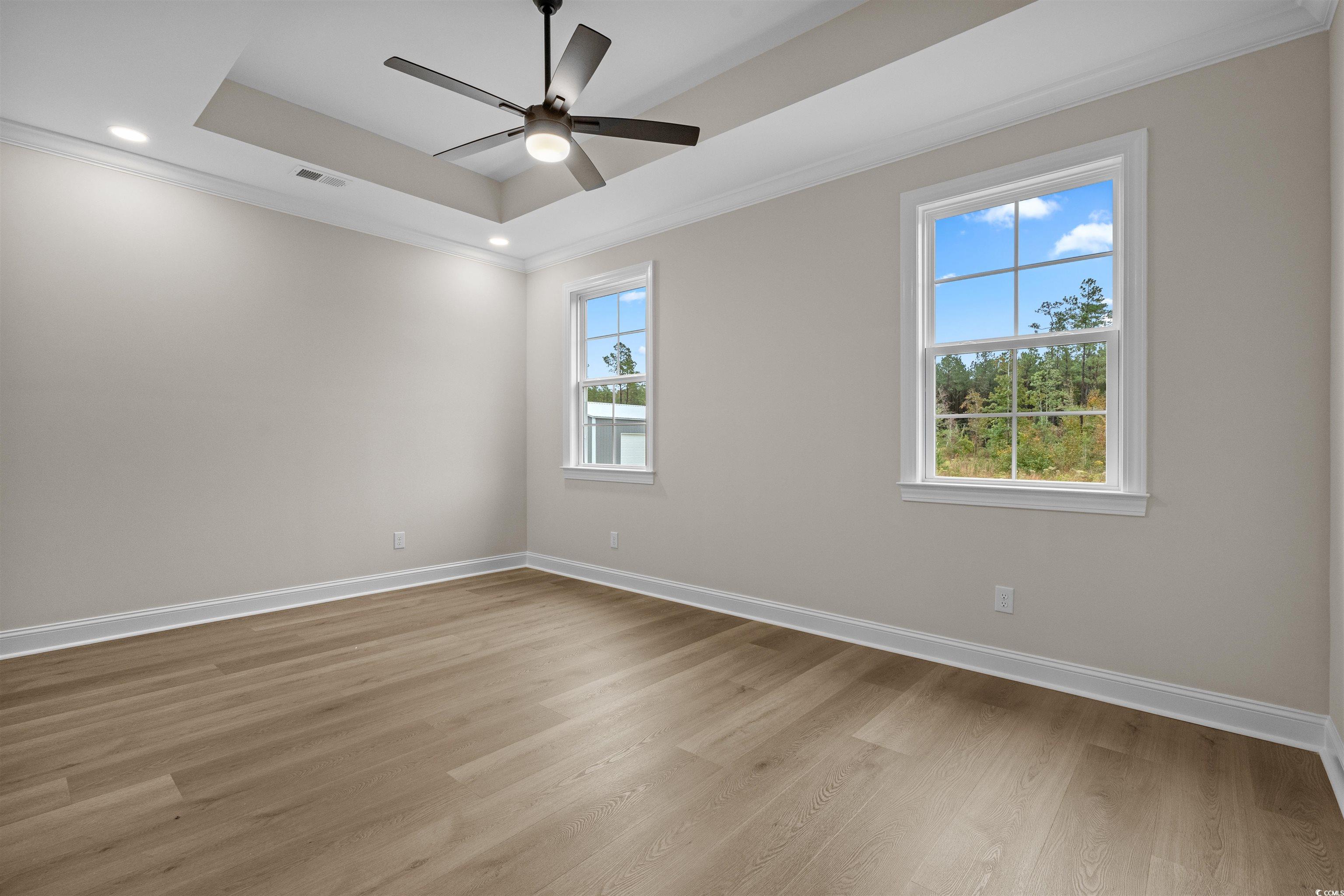 6927 Pauley Swamp Road Conway, SC 29527 - Photo 25 of 40 Spare room featuring a tray ceiling, crown molding, light wood-style floors, recessed lighting, and ceiling fan