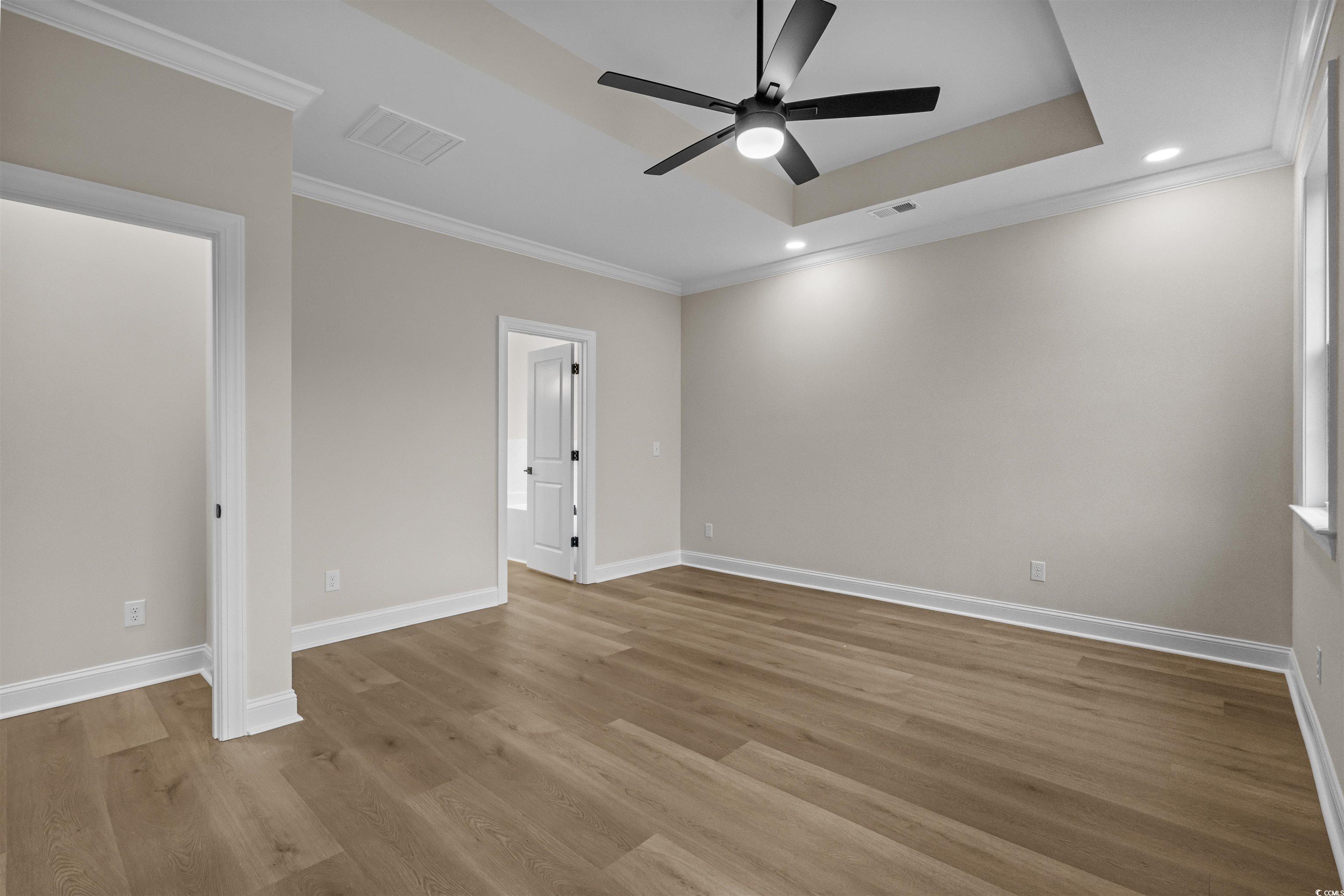 6927 Pauley Swamp Road Conway, SC 29527 - Photo 26 of 40 Unfurnished bedroom with ornamental molding, a tray ceiling, recessed lighting, light wood-style floors, and a ceiling fan