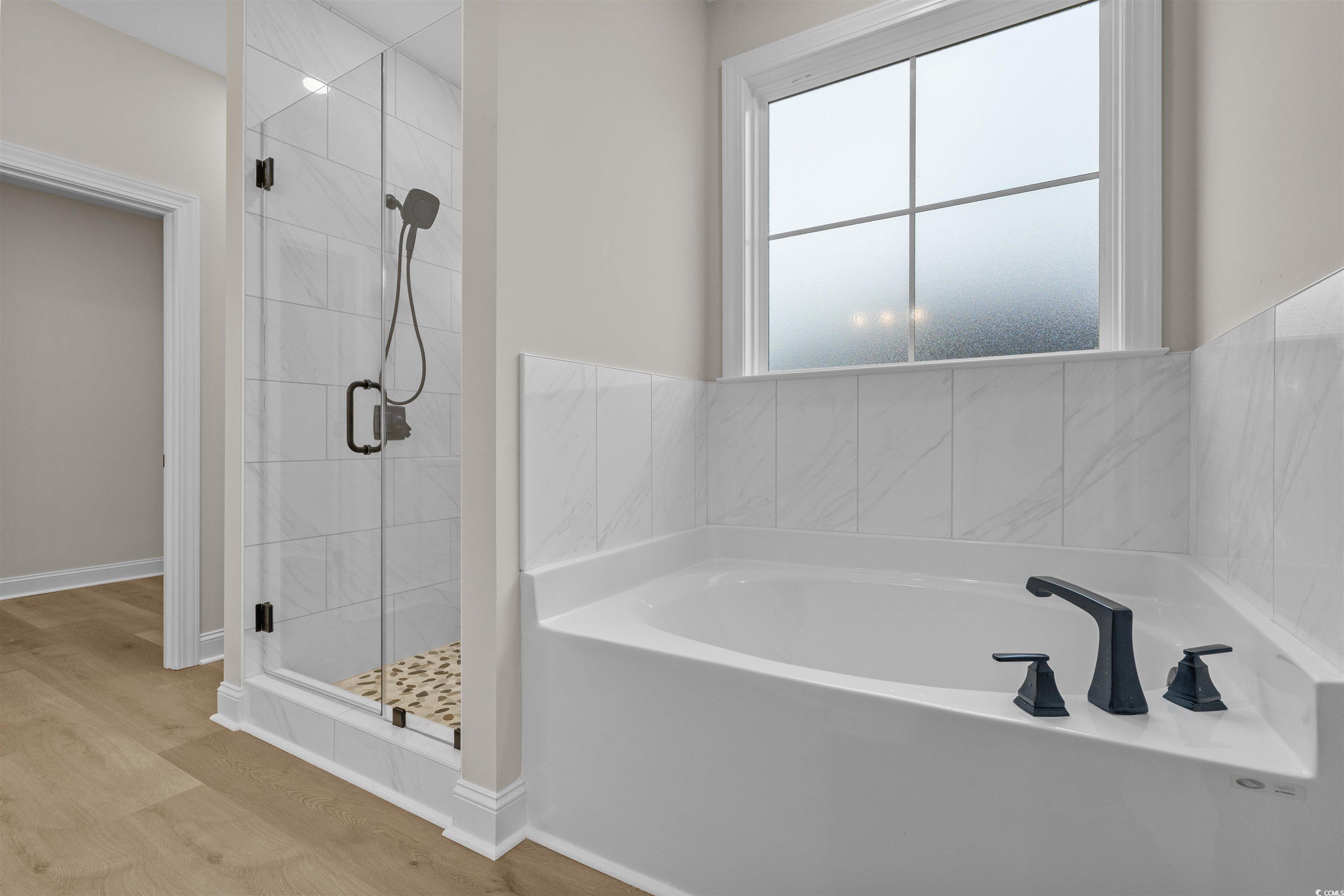 6927 Pauley Swamp Road Conway, SC 29527 - Photo 29 of 40 Full bathroom featuring a bath, wood finished floors, and a stall shower