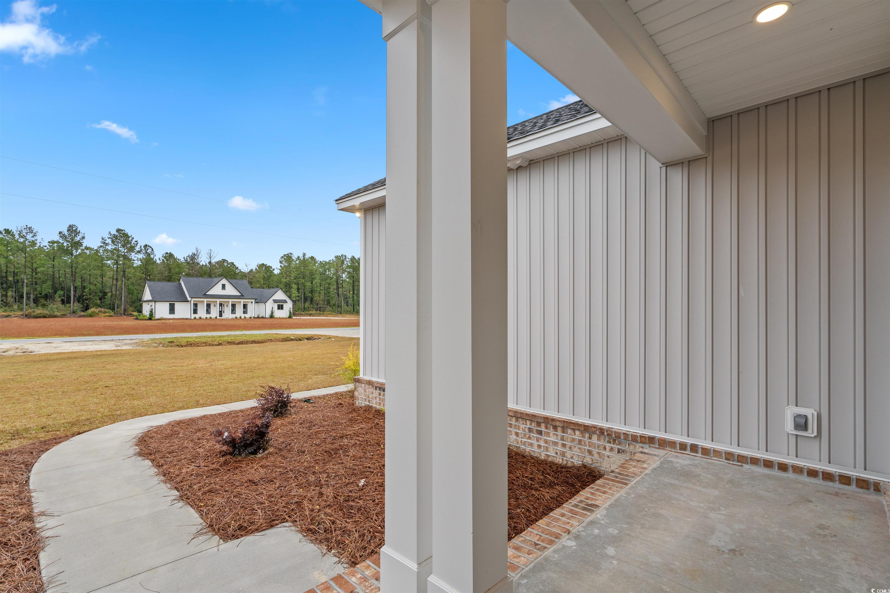 6927 Pauley Swamp Road Conway, SC 29527 - Photo 8 of 40 View of home's exterior featuring board and batten siding, a lawn, and a shingled roof