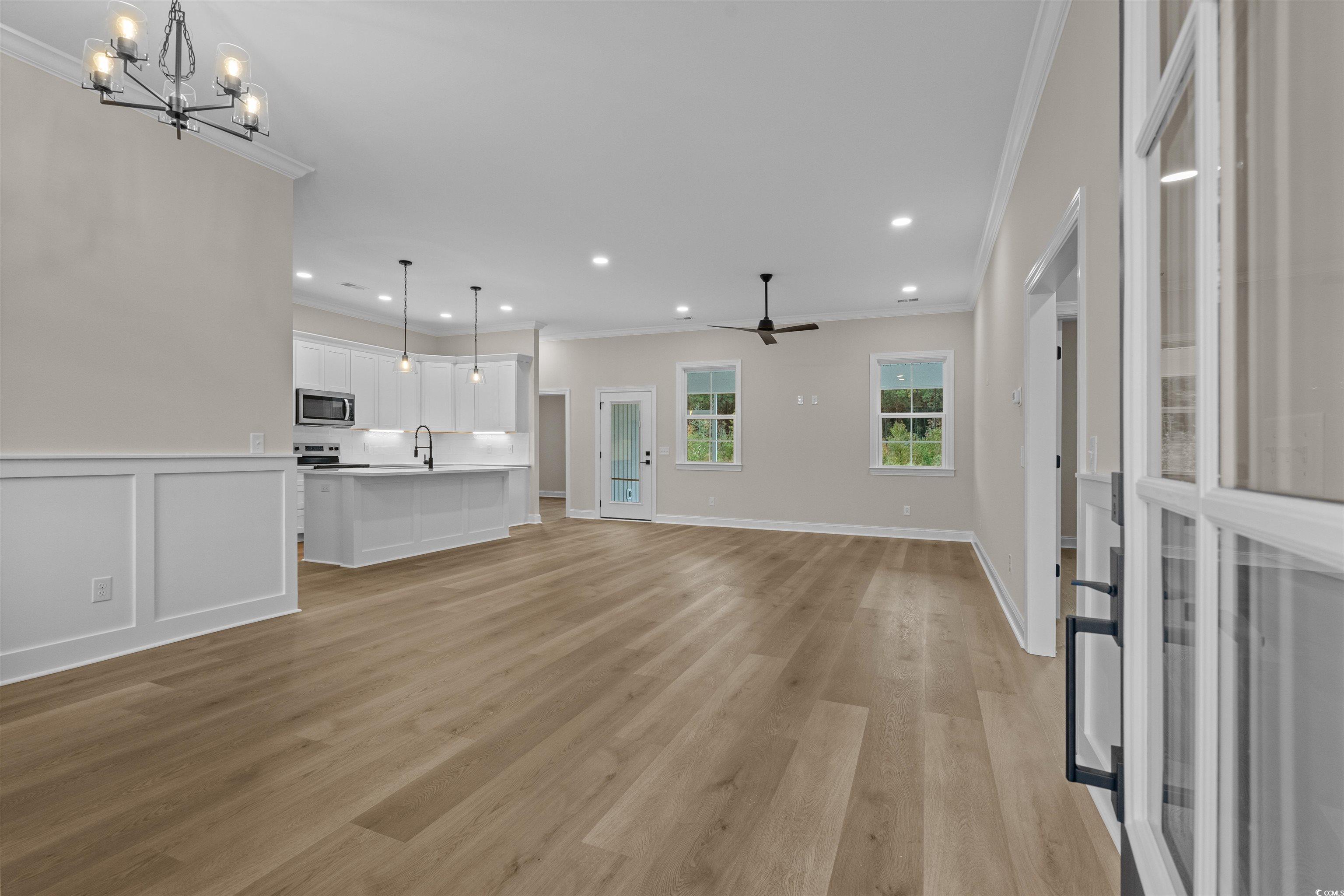 6927 Pauley Swamp Road Conway, SC 29527 - Photo 9 of 40 Unfurnished living room with crown molding, a ceiling fan, a chandelier, light wood-type flooring, and recessed lighting