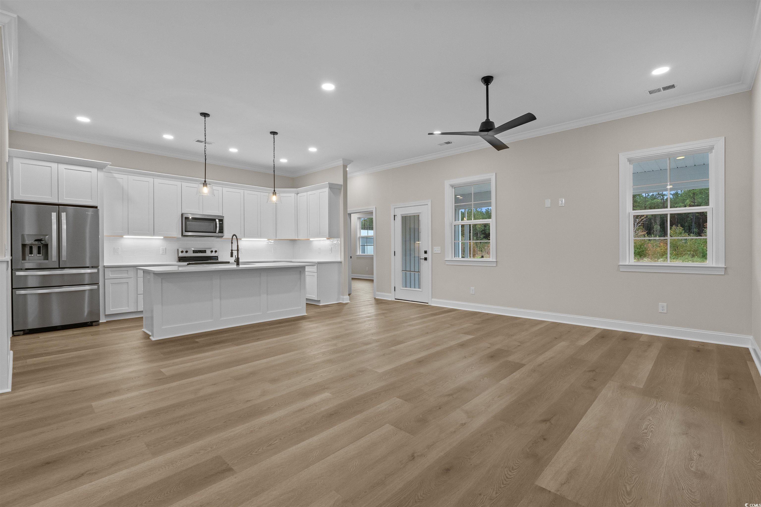 6927 Pauley Swamp Road Conway, SC 29527 - Photo 40 of 40 Kitchen with stainless steel appliances, ornamental molding, white cabinetry, open floor plan, and recessed lighting