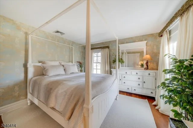 a bed room with a bed window and mirror