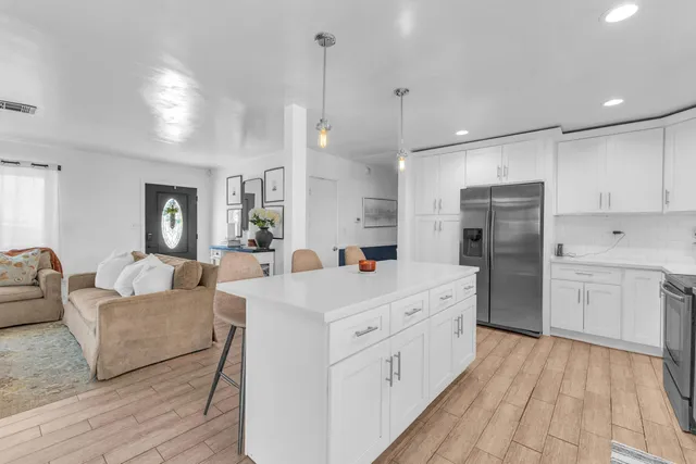 a kitchen with cabinets stainless steel appliances and wooden floor