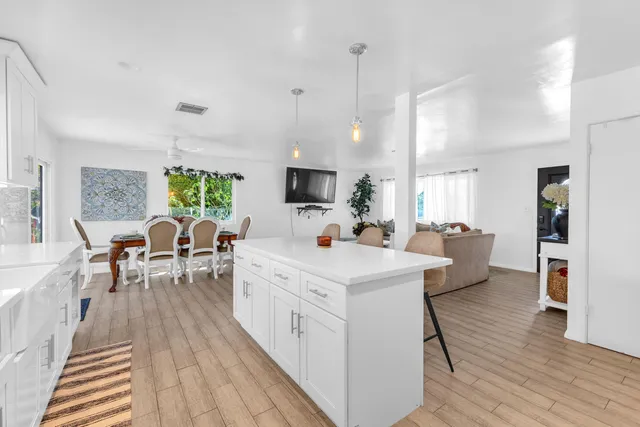 a living room with furniture a flat screen tv and a large window