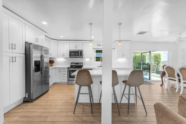 a bathroom with a granite countertop bathtub sink vanity mirror and toilet