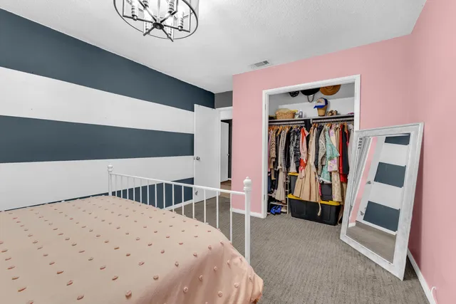 a spacious bedroom with a bed mirror and a desk