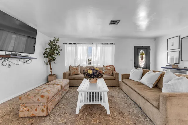 a living room with furniture and a dining table with kitchen view