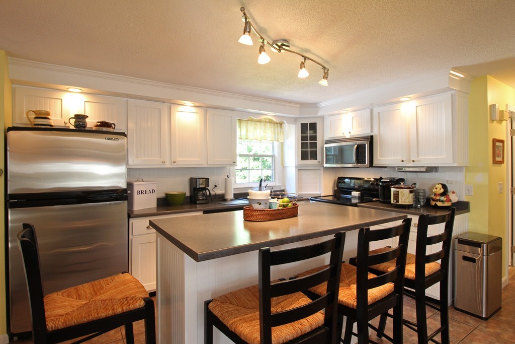 11 Bayberry Hill Road Townsend, MA 01469 - Photo 2 of 21 a kitchen with a dining table chairs refrigerator and microwave
