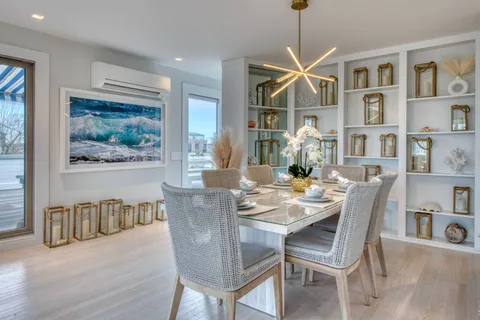 a dining room with furniture a book and wooden floor