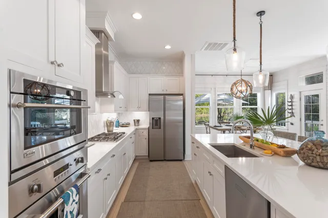 a kitchen with white cabinets and appliances