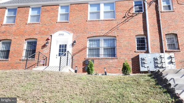 front view of a brick house with a yard