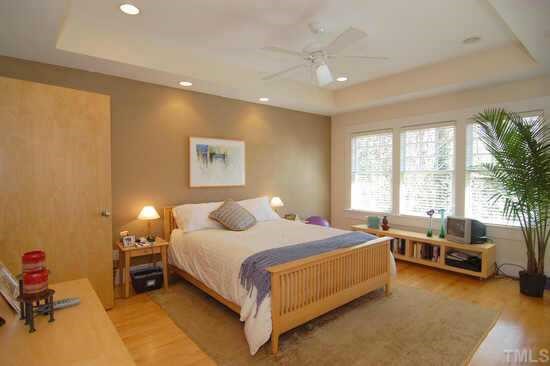 2718 Cambridge Road Raleigh, NC 27608 - Photo 8 of 12 a bedroom with a bed and a chandelier