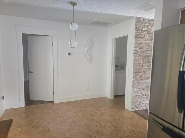 a view of an empty room with cabinet and door