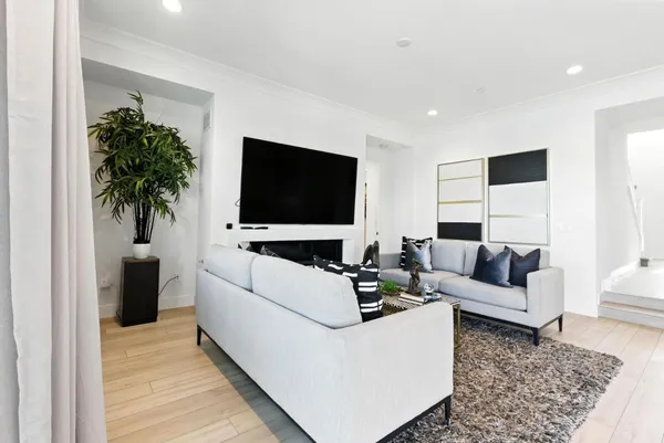 a living room with furniture wooden floor and a large window
